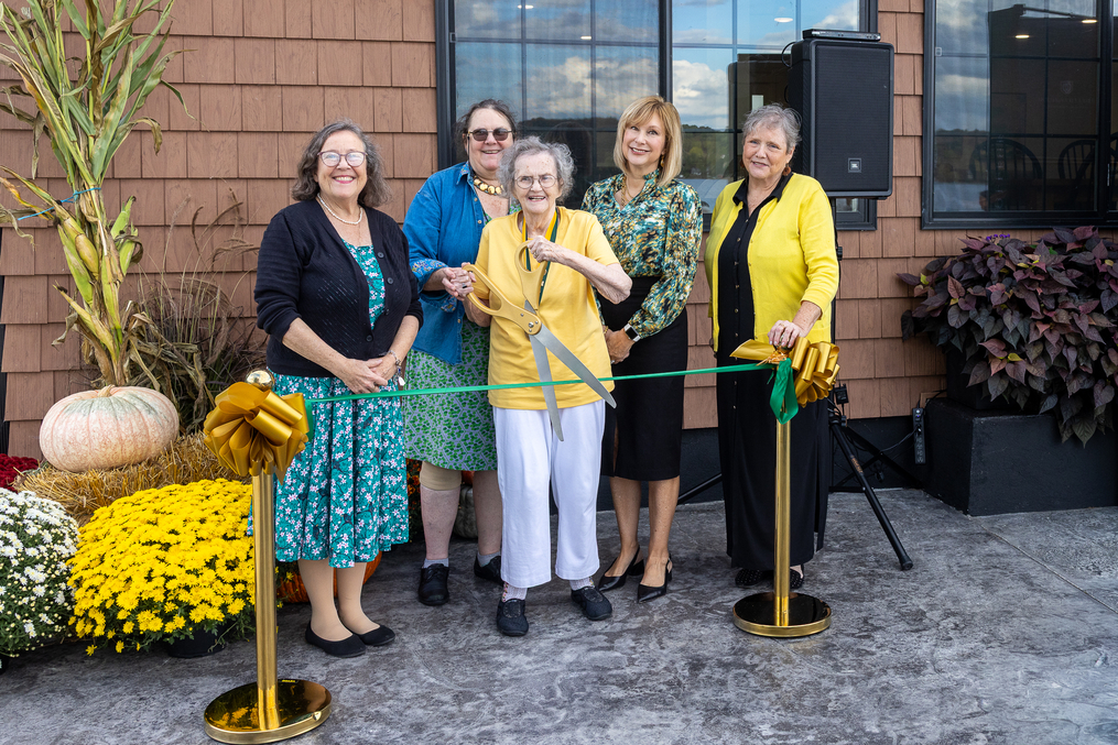 Dorisanne Osborn ’51 is joined by family members and President Storey as she cuts the ribbon on the new Lakeside Lodge, which was created through renovations of Dorisanne's former home.