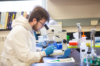 Austin Glazer '22 looking into microscope 